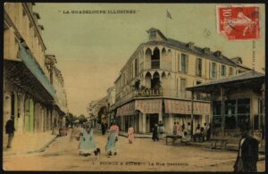 [FOCUS SUR] Carte postale colorisée de Pointe-à-Pitre, rue Gambetta, début XXe siècle.